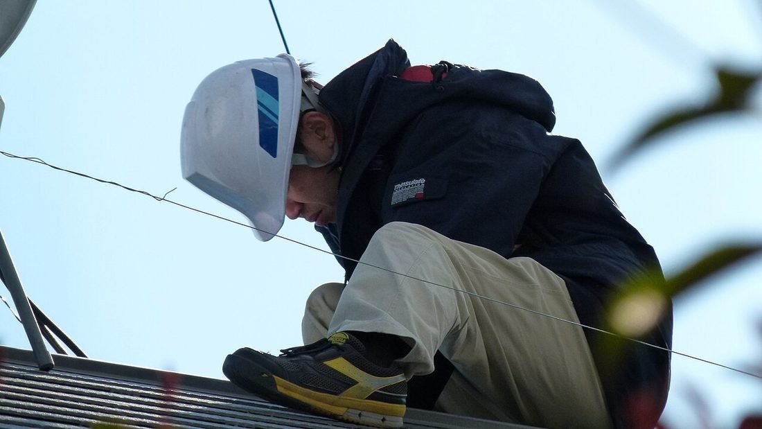 Installers fitting a rooftop solar installation on a building, the kind of work the best solar company in Raipur should document