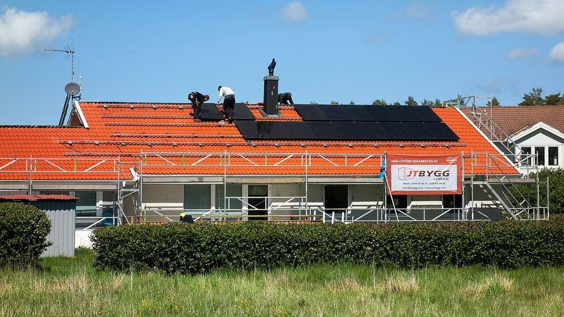Installers fitting solar panels on a house roof, as done by a solar installer in Raipur