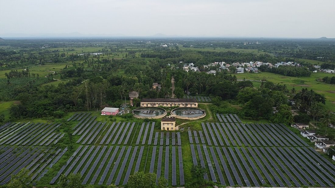Aerial view of a solar plant across green farmland in India, representing the units your bill measures