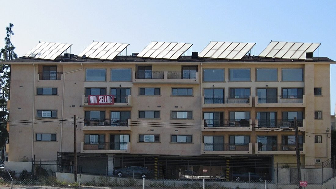Apartment building with solar panels on its roof, an example of solar for housing societies and apartments in Raipur