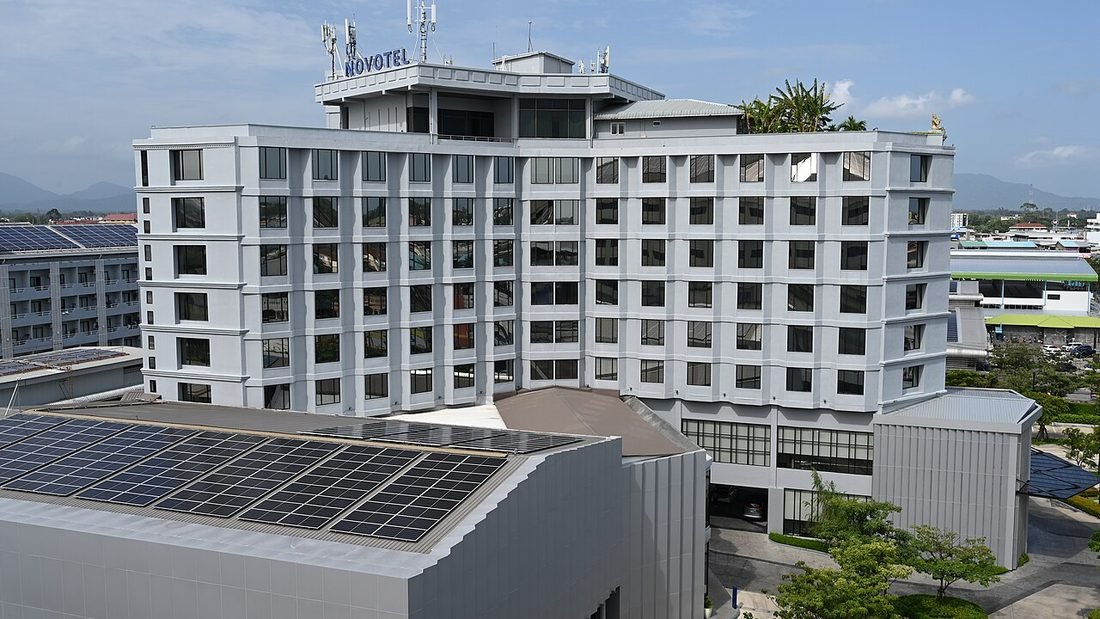 Mid-rise hotel complex with solar panels on its rooftop, an example of solar for hotels