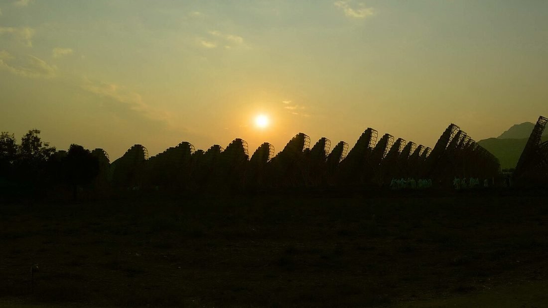 Row of solar parabolic dishes at a spiritual institution's solar installation in India