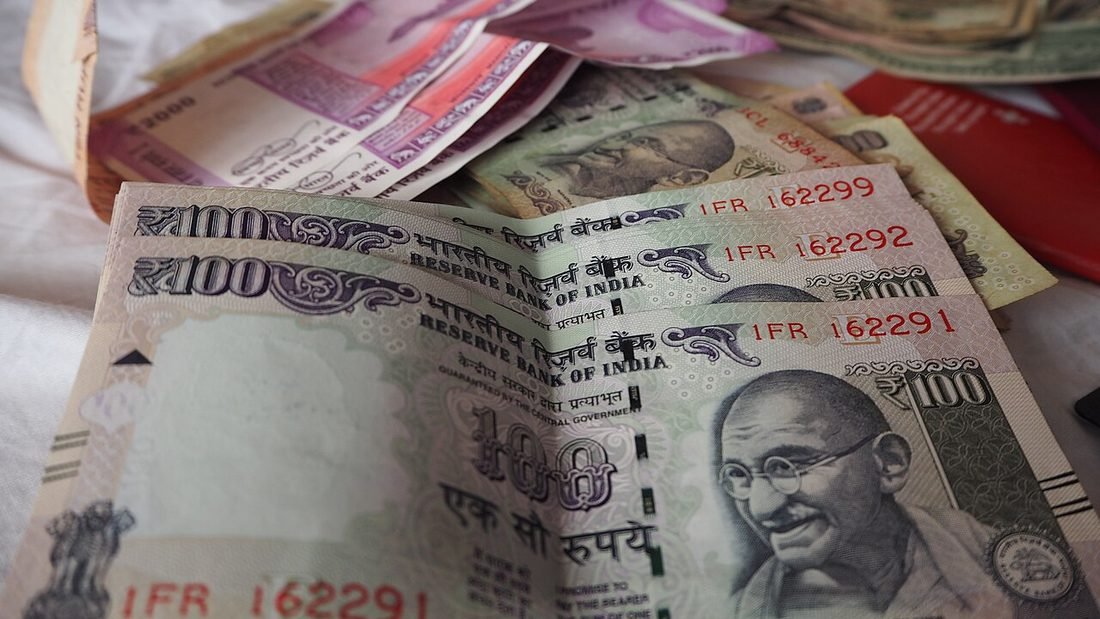 Indian rupee banknotes, representing the cost and financing of a rooftop solar system through a solar loan and EMI