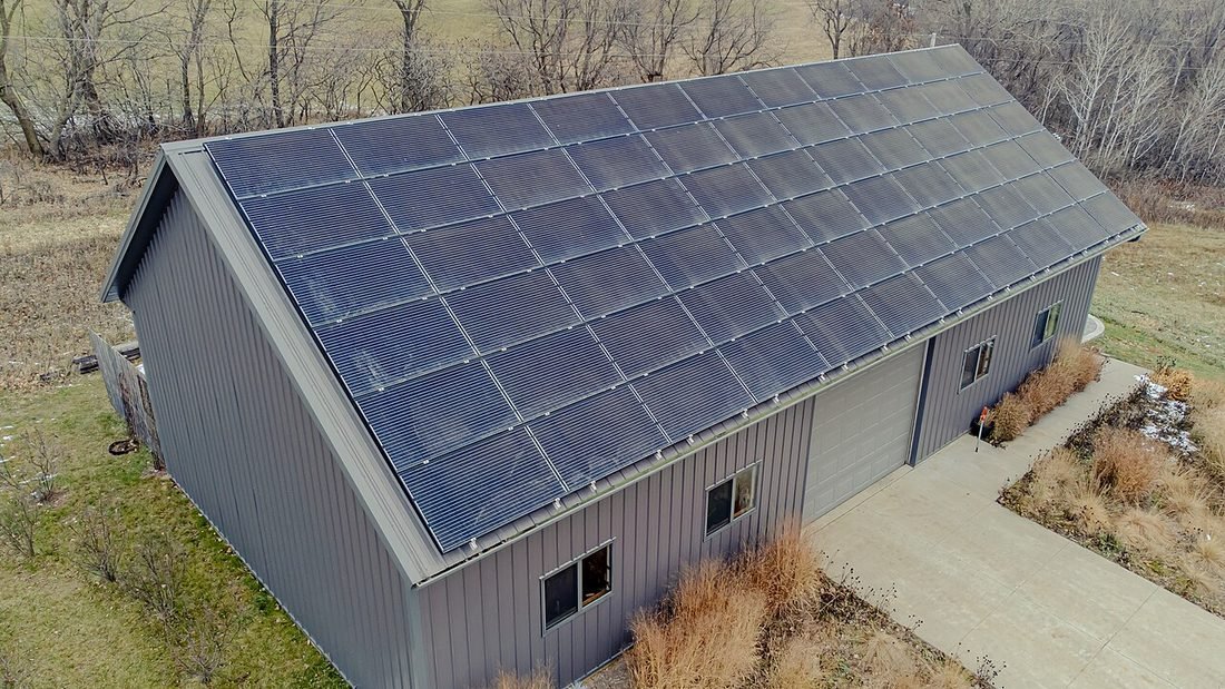 Metal shed with solar panels covering its roof, showing rooftop solar on a sheet roof or tin shed