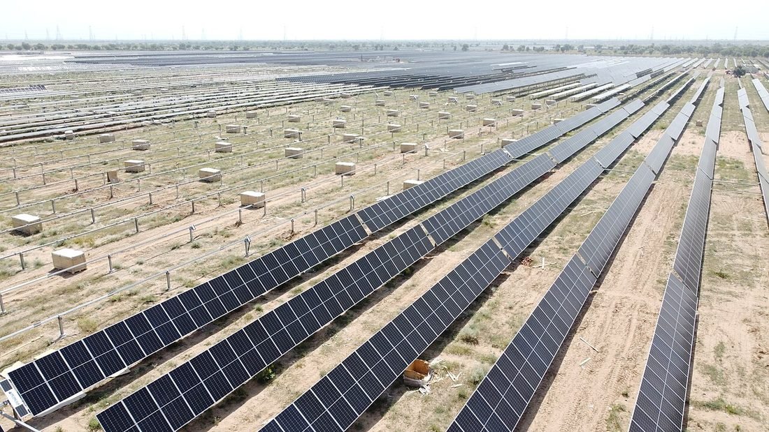 Rows of solar panels on open land beside an electrical substation, illustrating common questions about solar in Raipur