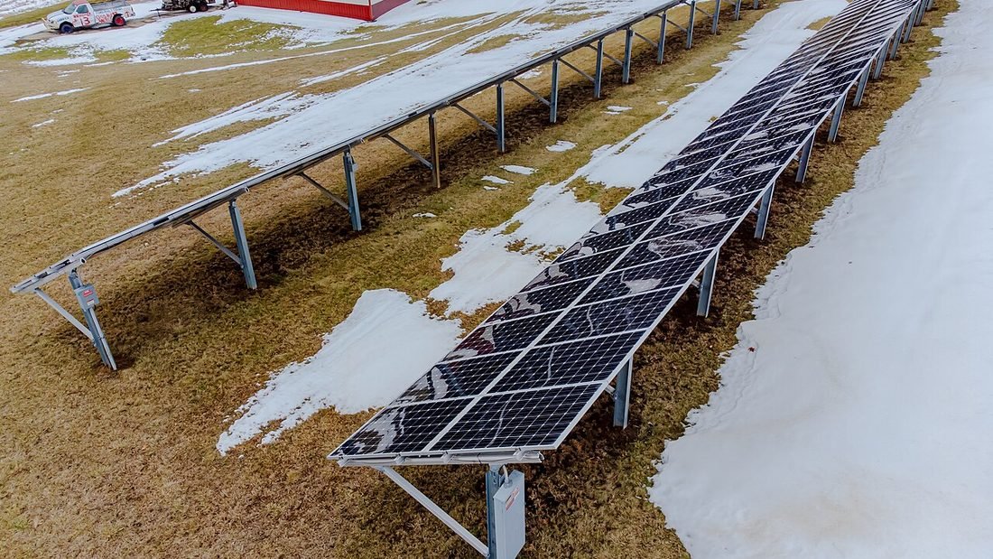 Ground-mounted solar panels on racks, representing choosing a system size from the monthly electricity bill